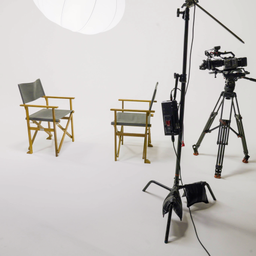 White cyclorama with two directors chairs and camera set up